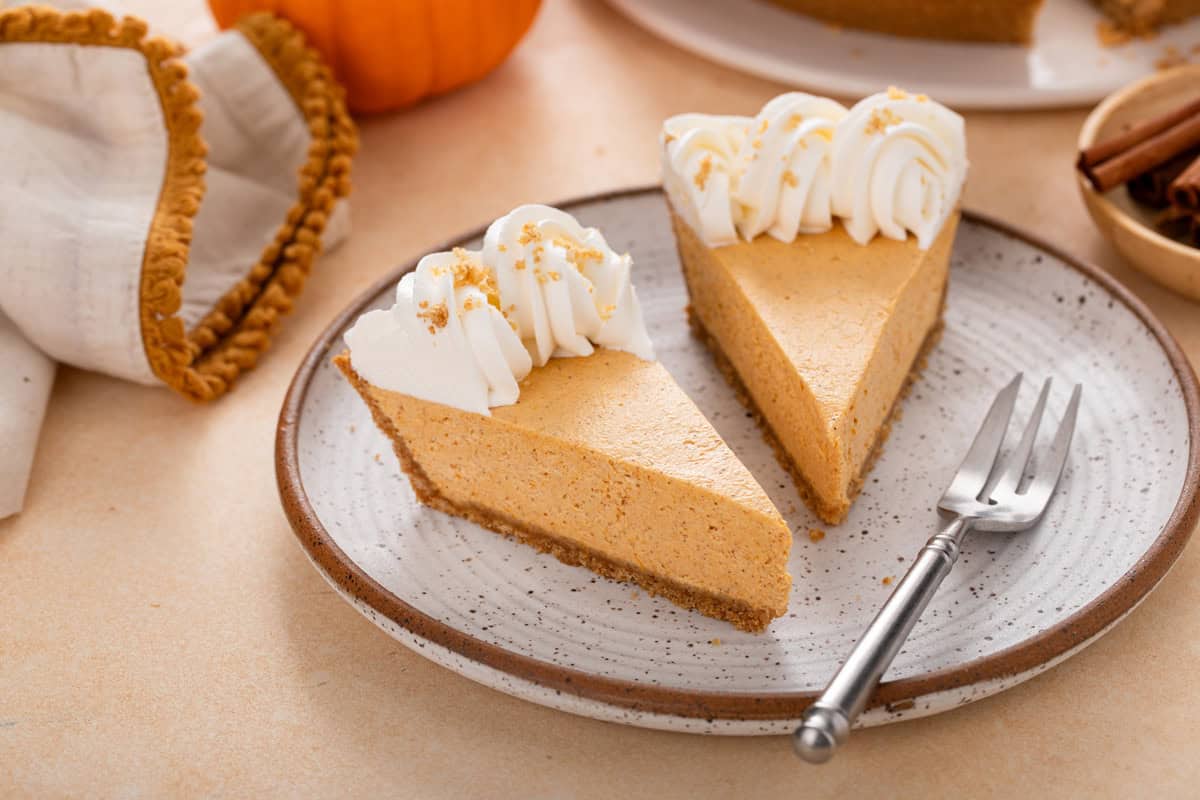 Two slices of no-bake pumpkin cheesecake pie on a plate.