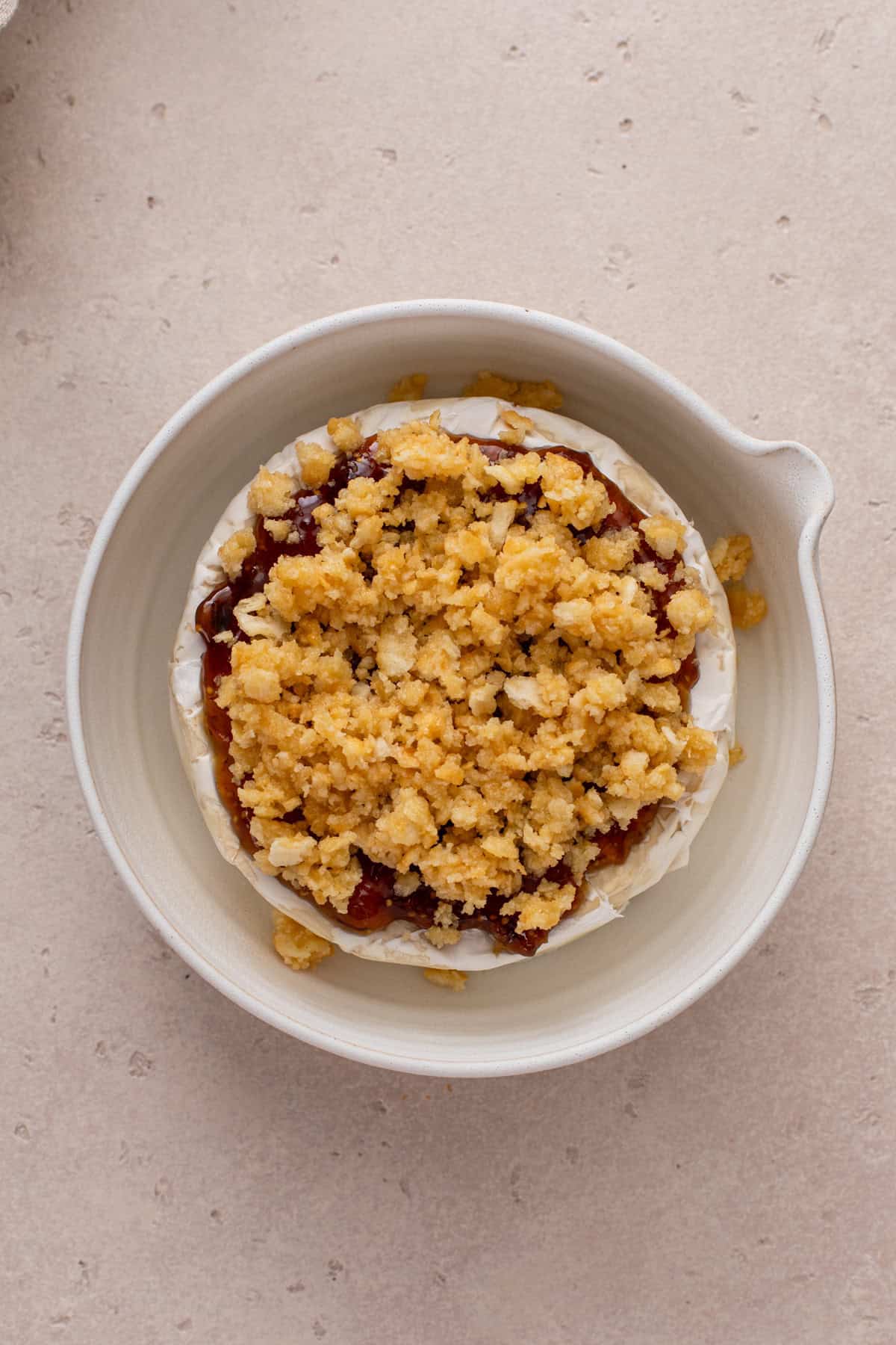 Buttered crushed crackers on top of jam-topped brie.
