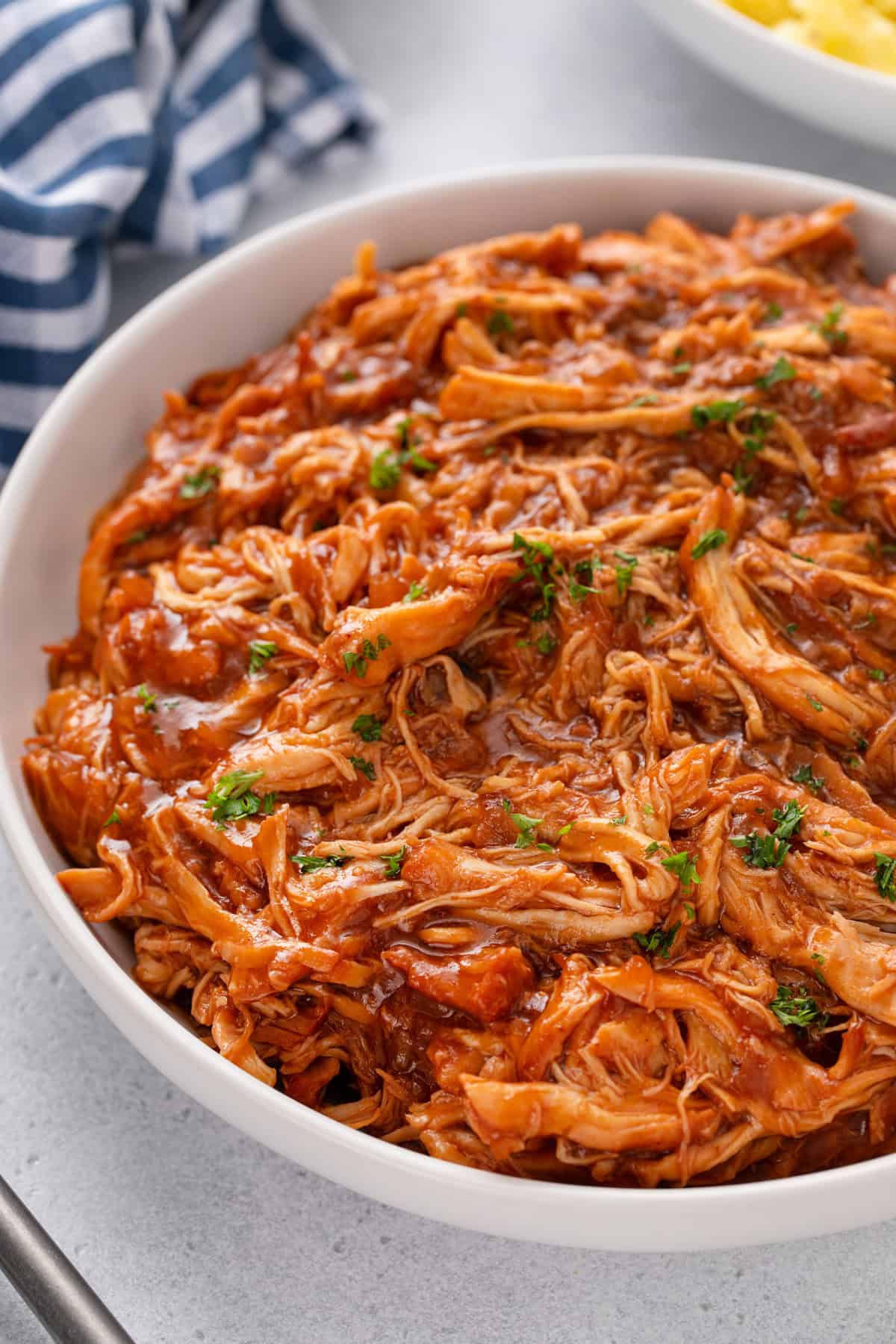 Close up of cranberry chicken in a white serving bowl.