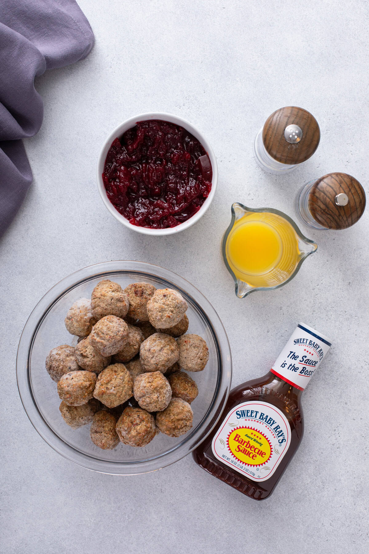 Ingredients for cranberry meatballs arranged on a countertop.