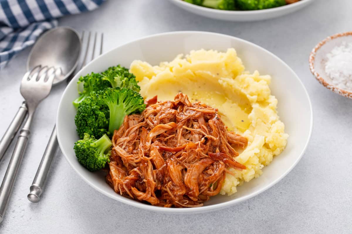Cranberry chicken plated with mashed potatoes and broccoli.