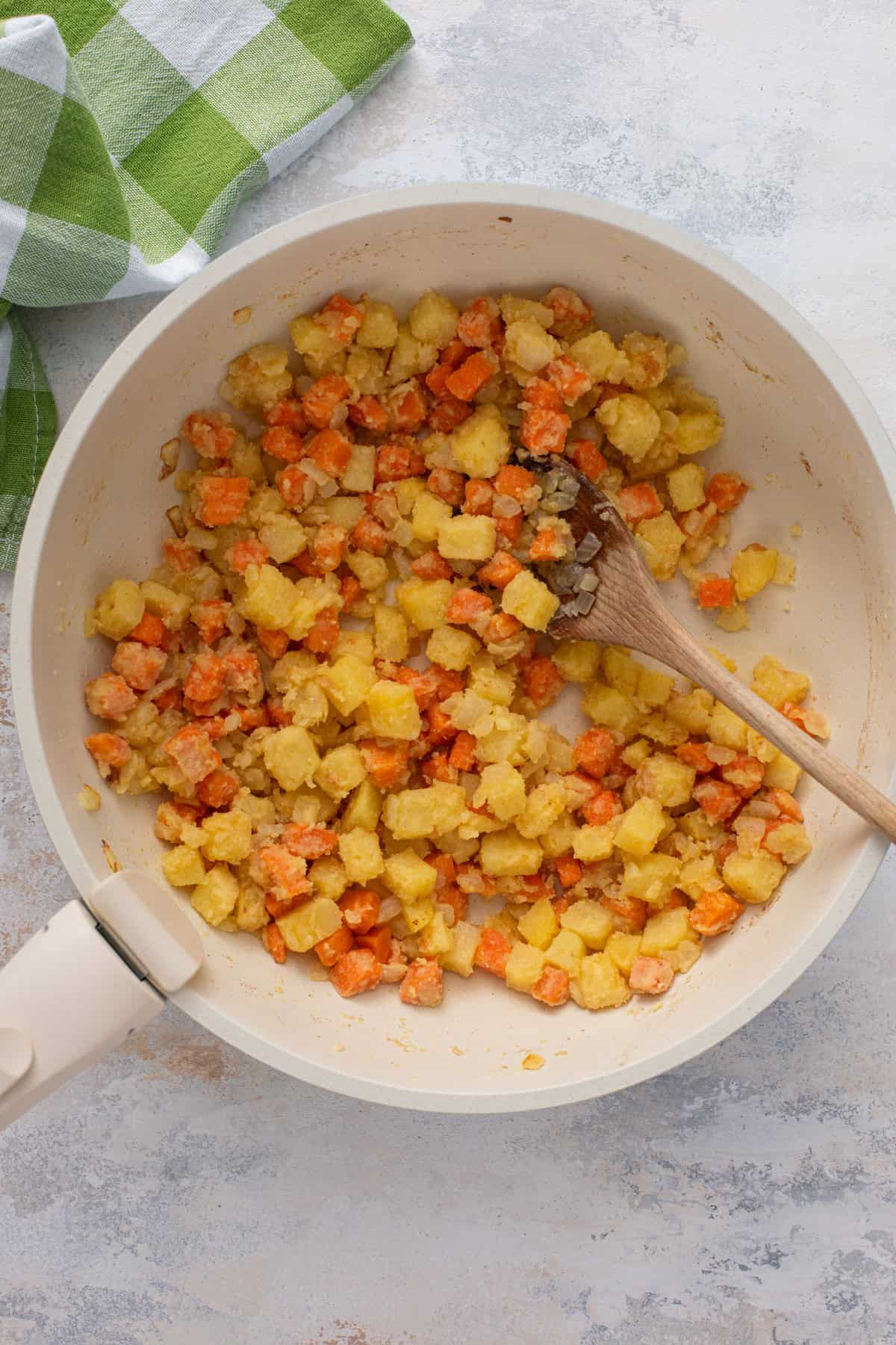 Sauteed vegetables coated with flour in a skillet.