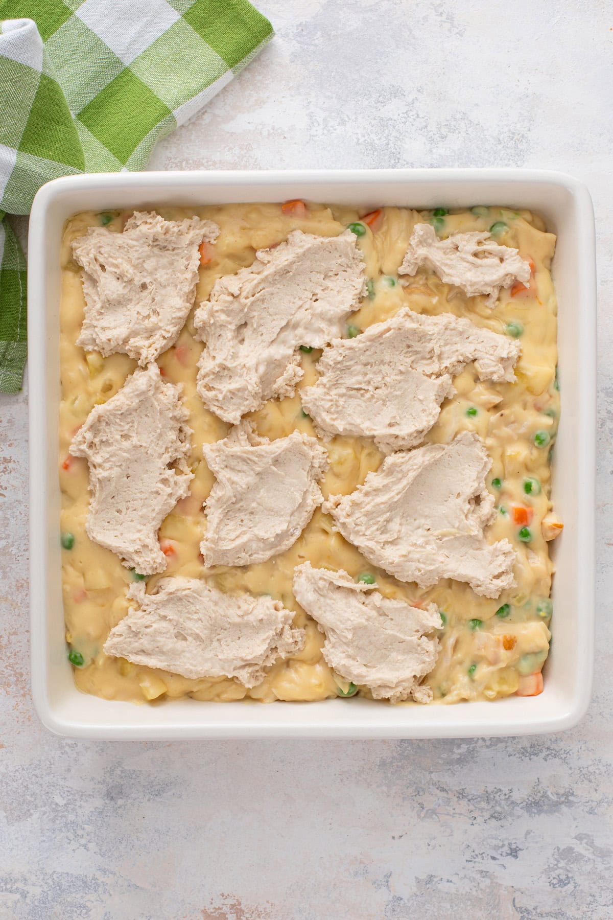 Unbaked bisquick chicken pot pie in a baking dish, ready to go in the oven.