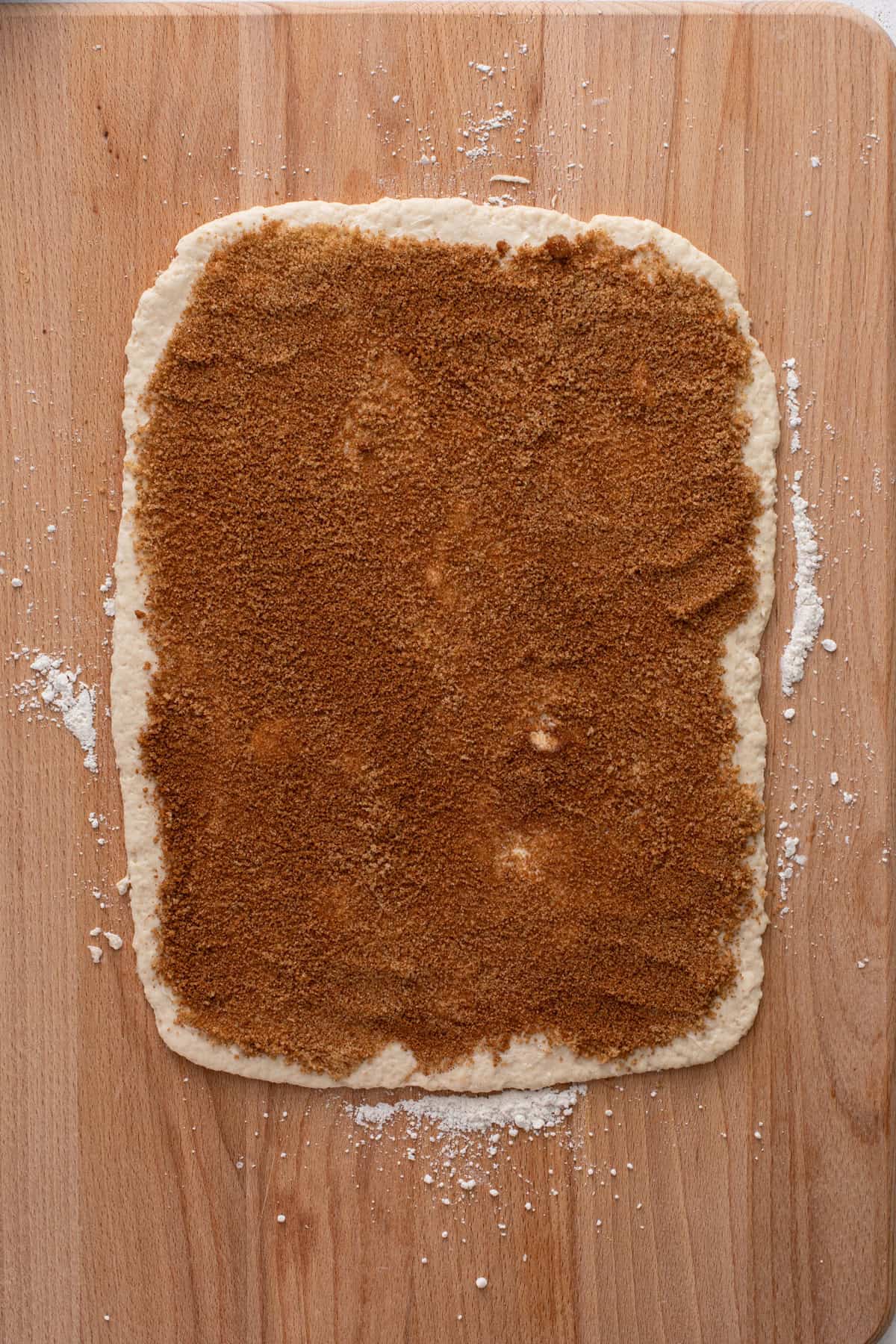 Cinnamon-sugar mixture on top of buttered biscuit dough for cinnamon rolls.