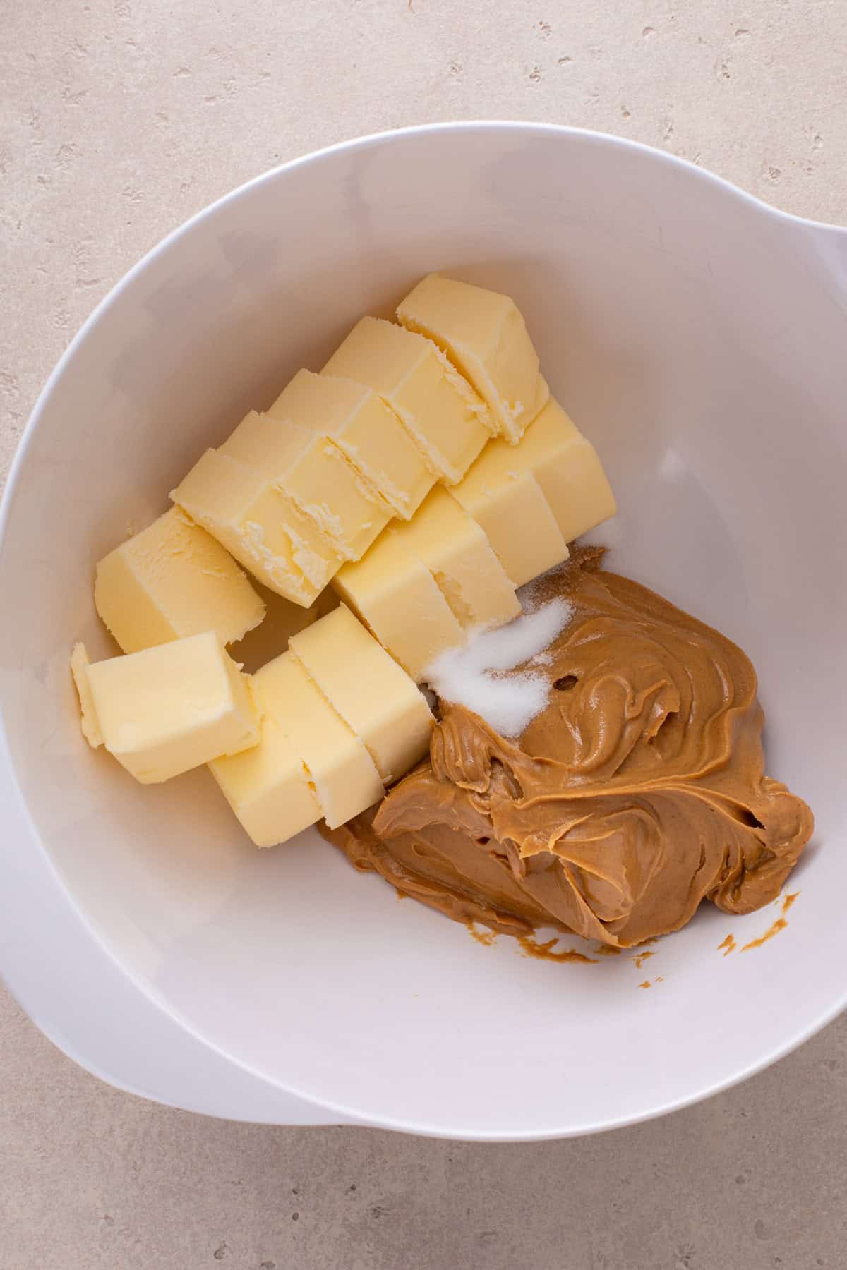 Peanut butter, butter, and salt added to a mixing bowl.