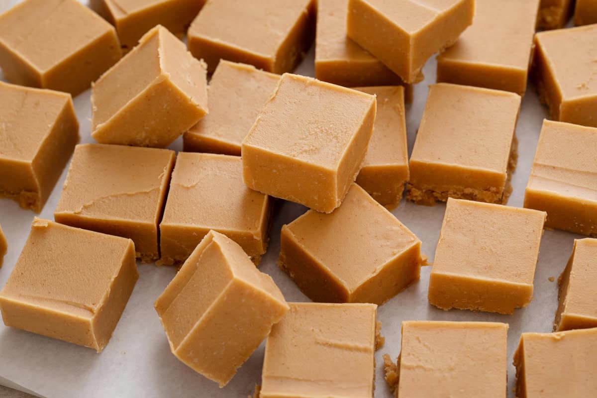 Squares of peanut butter fudge arranged on a piece of parchment paper.