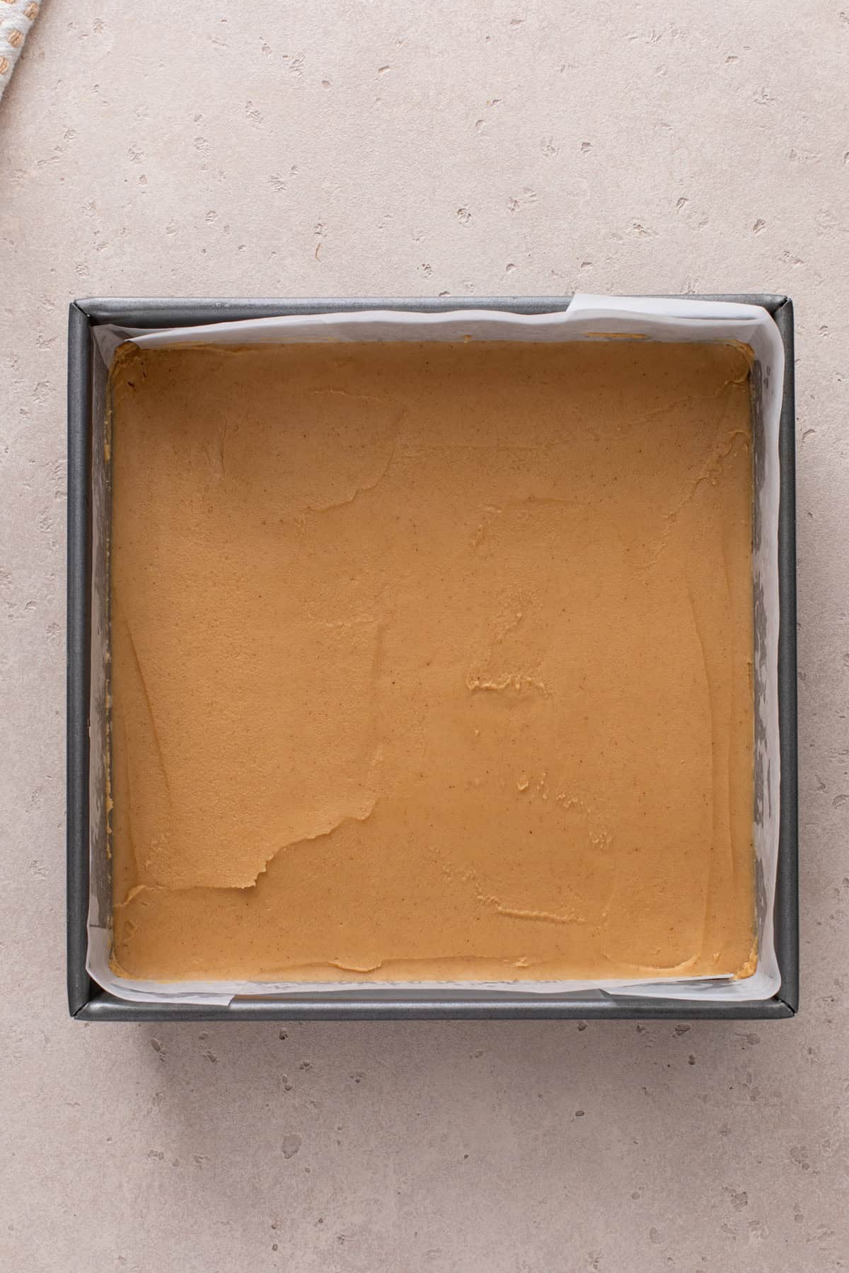 Peanut butter fudge mixture spread into a lined pan.