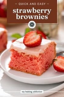 Close up image of strawberry brownie on a white plate, garnished with halved fresh strawberries. Text overlay includes recipe name.