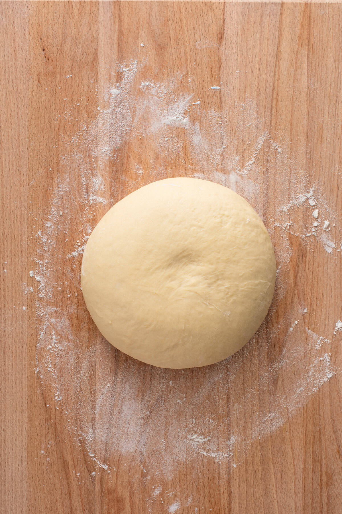 Kneaded dough for potato bread on a floured cutting board.