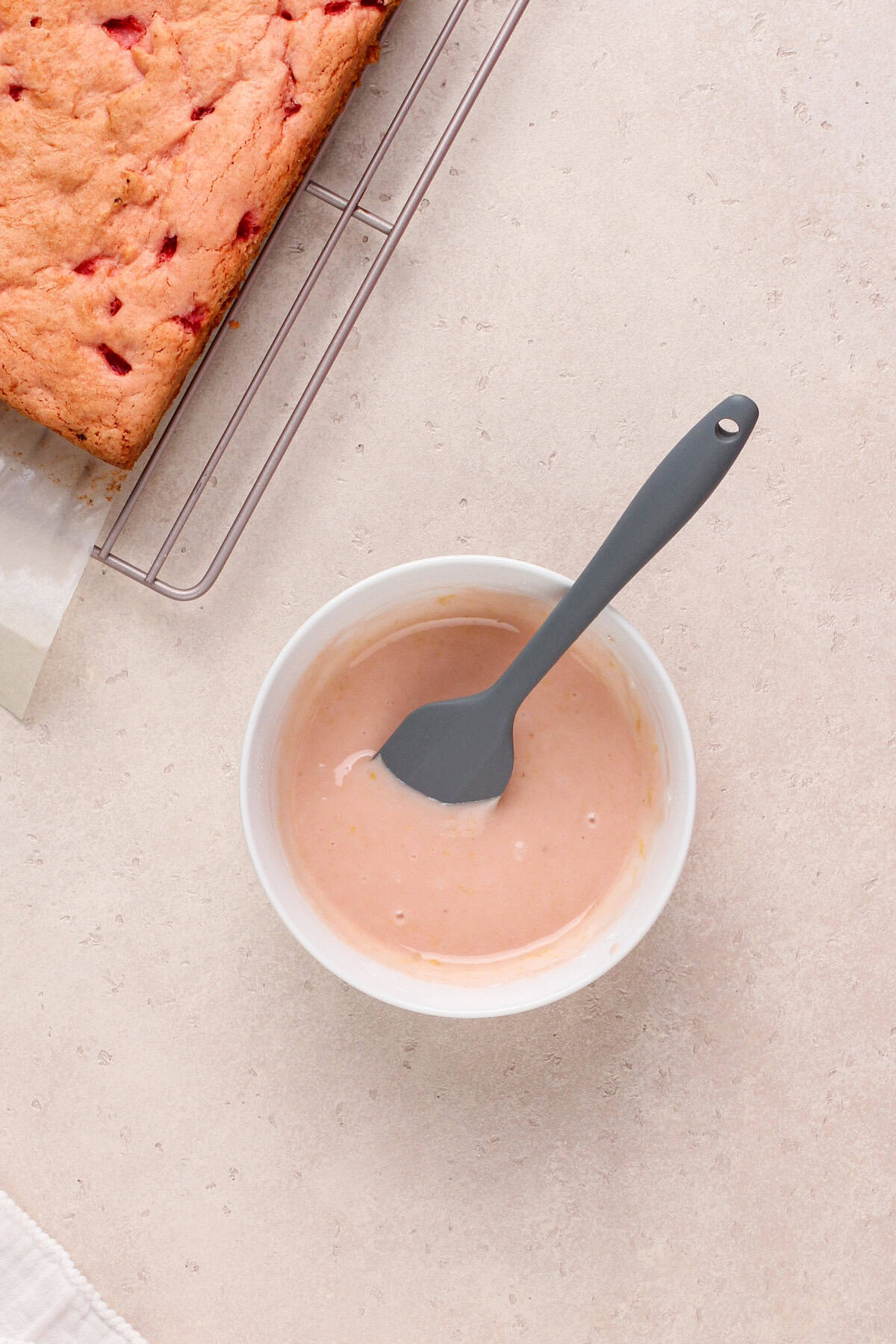 Glaze for strawberry brownies whisked in a white bowl.