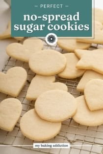 Assorted shapes of no-spread sugar cookies arranged on a wire rack on a countertop. Text overlay includes recipe name.
