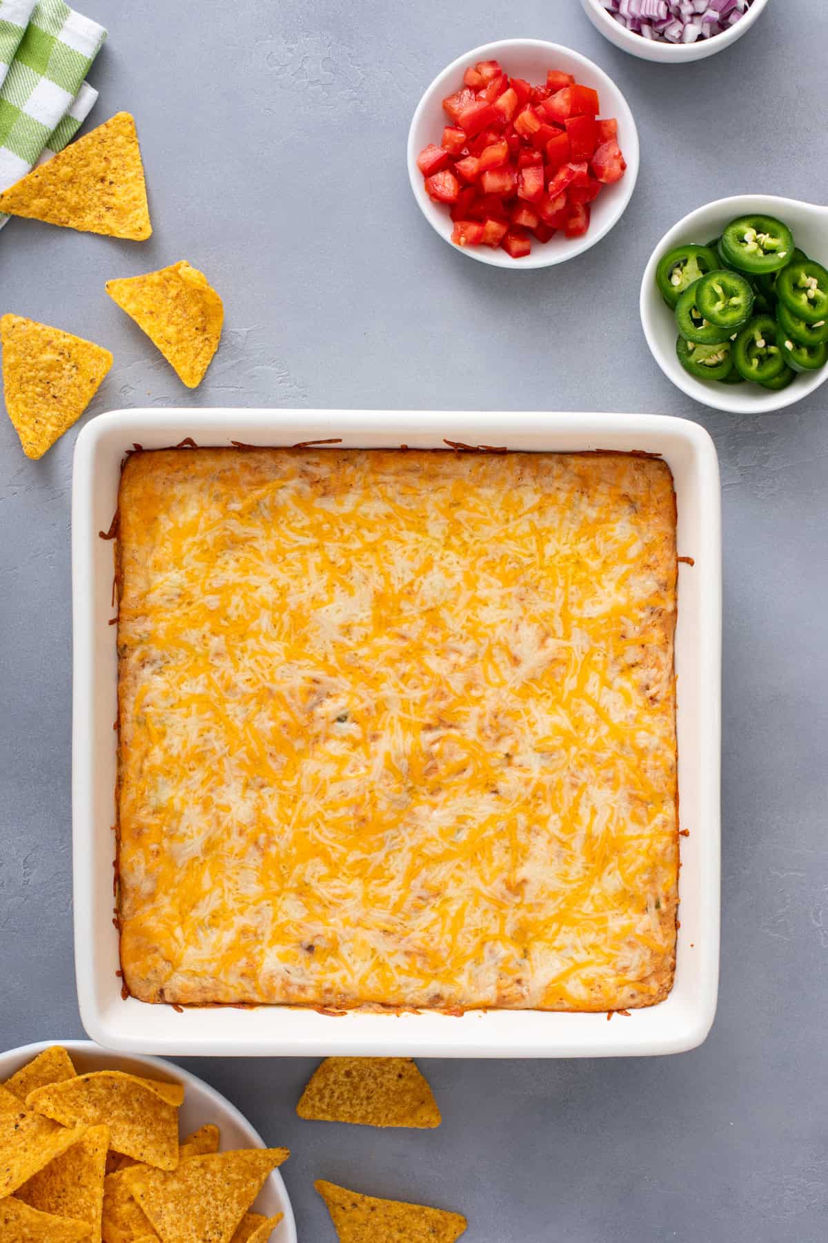 Baked texas trash dip in a white baking dish, ready to be garnished.