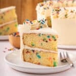 Slice of easy funfetti layer cake on a white plate.