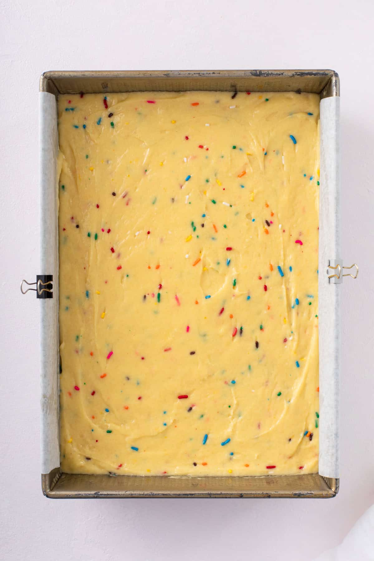Easy funfetti cake batter spread into a 9x13 pan, ready to go in the oven.