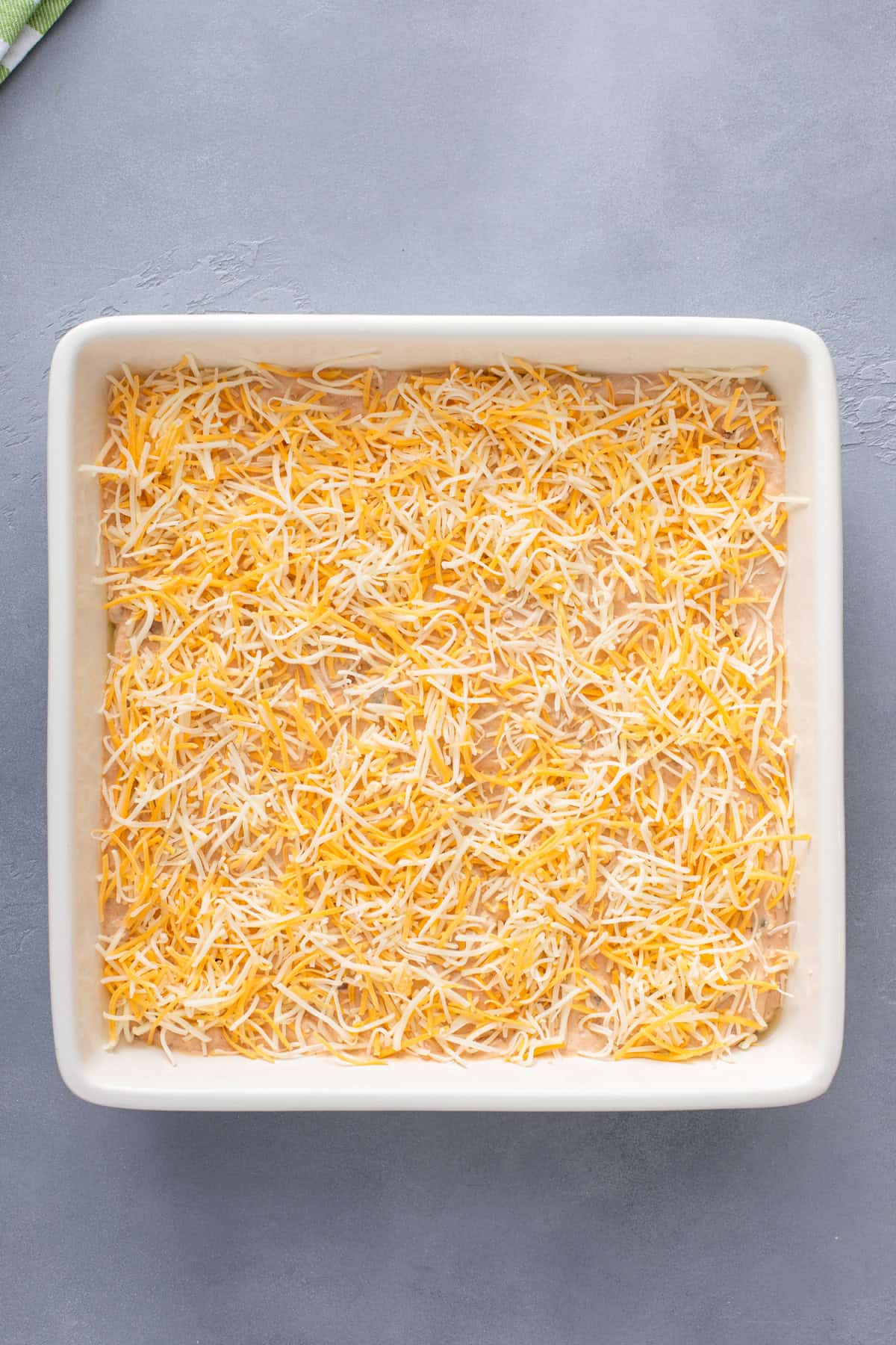 Unbaked texas trash dip in a white baking dish, ready to go in the oven.