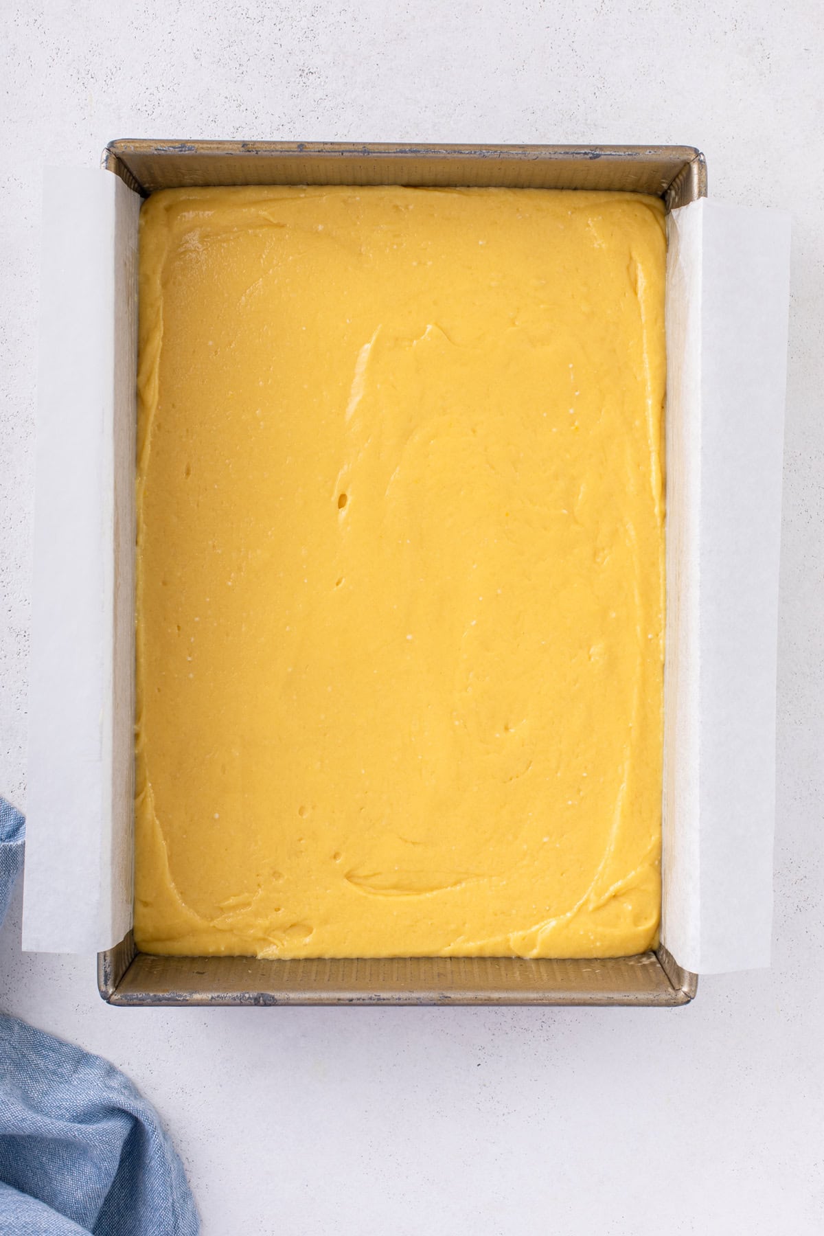 9x13-inch cake pan filled with yellow cake batter, ready to go in the oven.