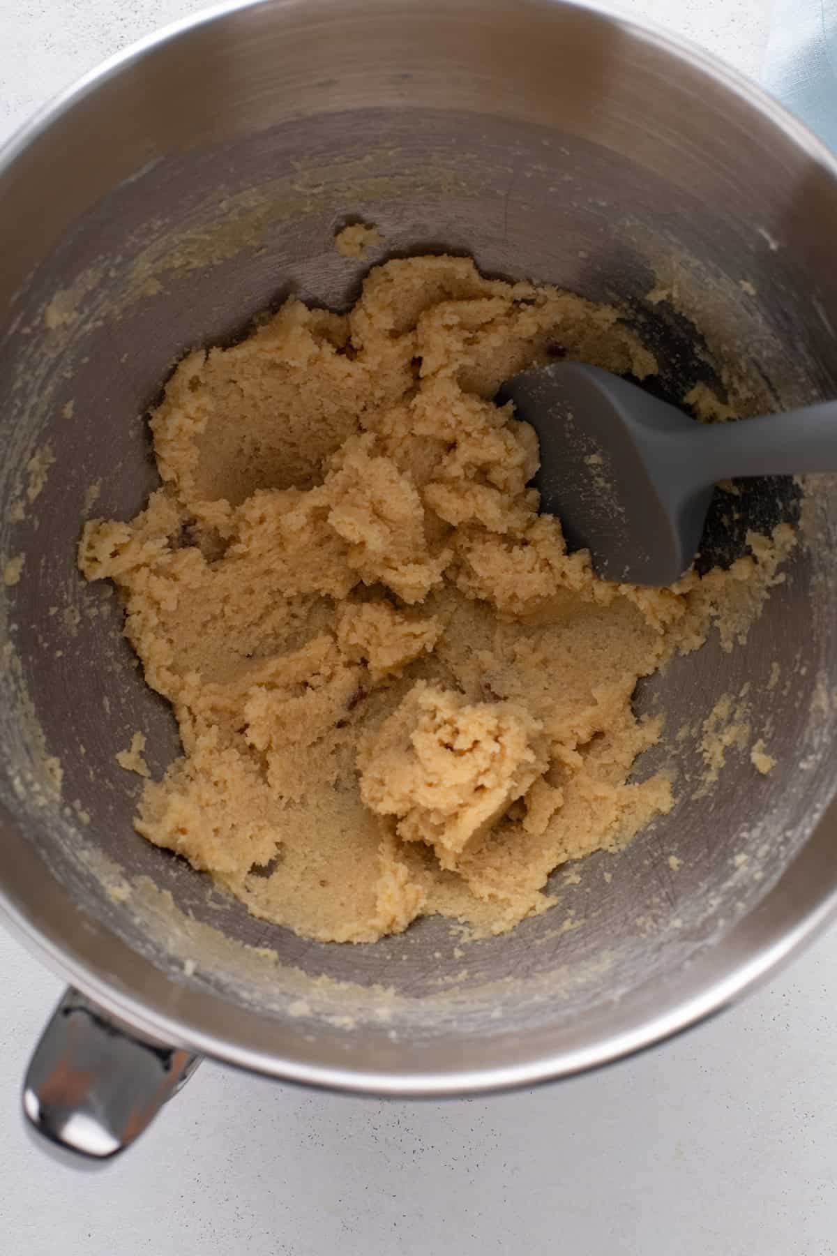 Butter and sugar for carrot cake cookies creamed together in a metal bowl.