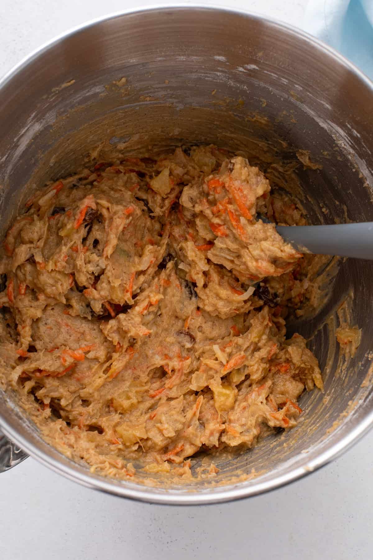 Carrot cake cookie dough mixed in a metal bowl.