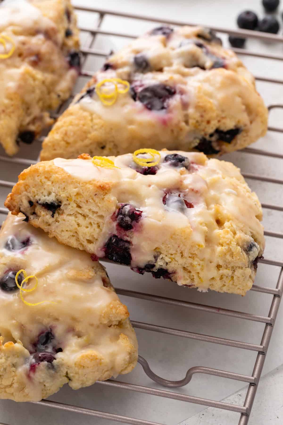 Close up of lemon blueberry scones arranged on a wire rack.