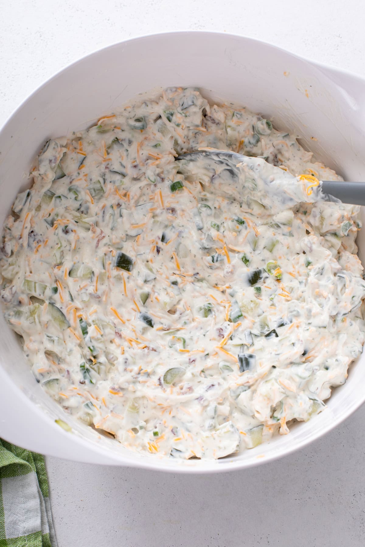 Pickle dip mixed in a white bowl, ready to be chilled in the fridge.