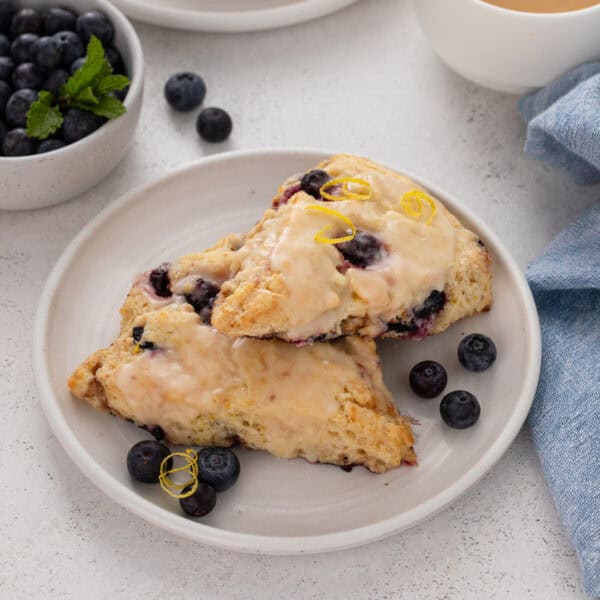 Two lemon blueberry scones on a white plate.