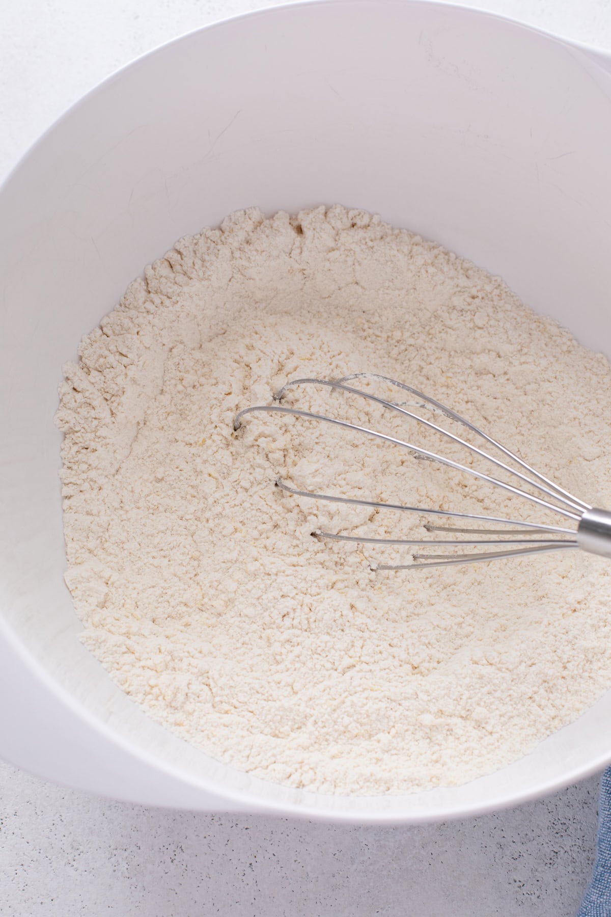 dry ingredients for lemon blueberry scones whisked in a white bowl.