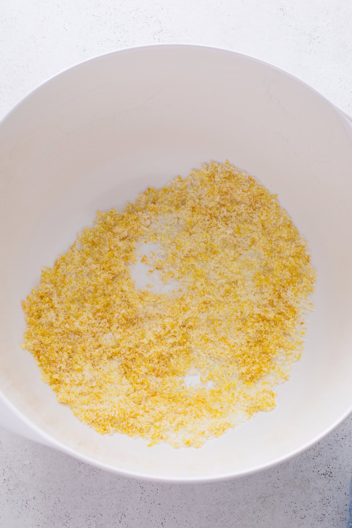 Lemon zest and sugar combined in a white bowl.