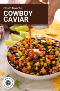 Chipotle lime vinaigrette dressing being drizzled over cowboy caviar in a white bowl. Text overlay includes recipe name.