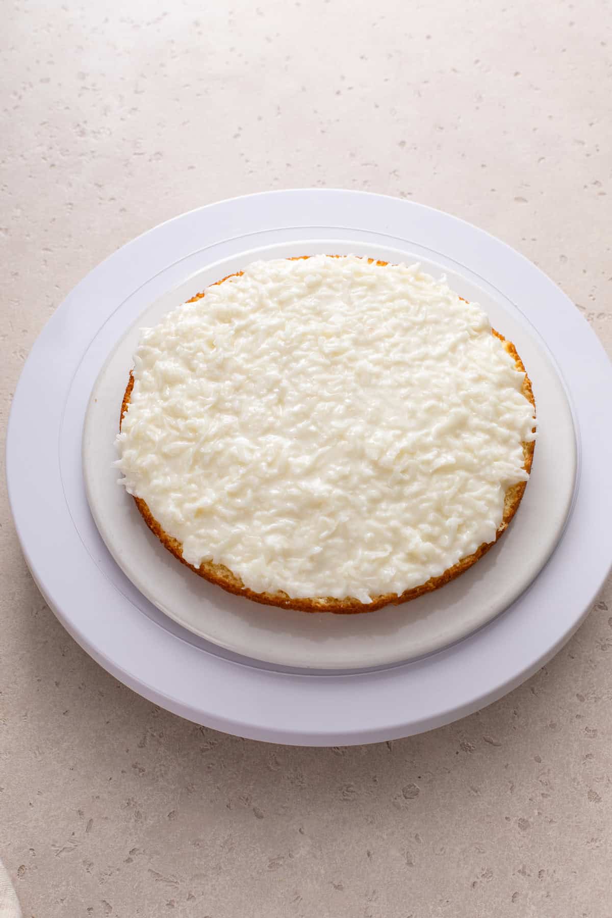 Sour cream and coconut filling spread onto a layer of butter cake.