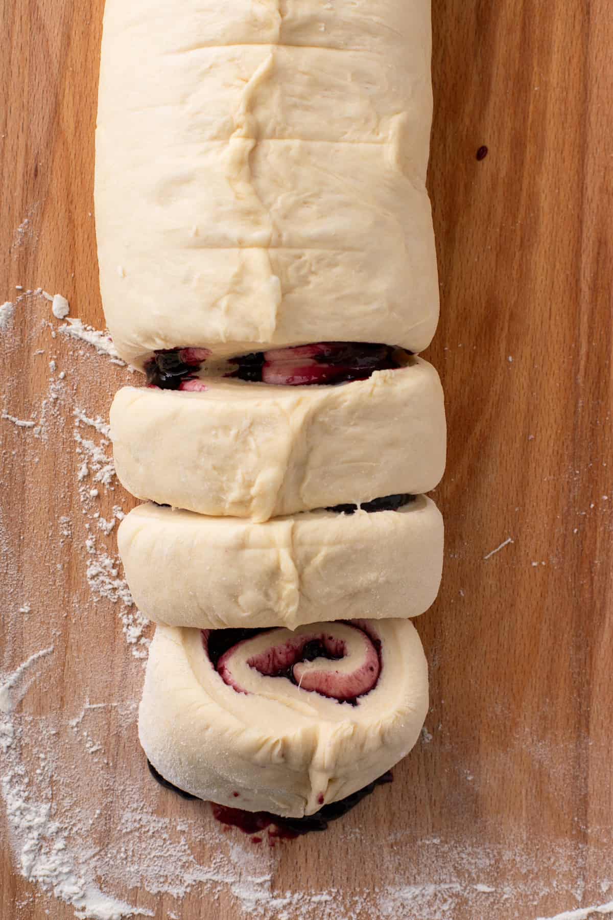 Sweet roll dough filled with blueberry preserves and rolled, then cut into pieces.