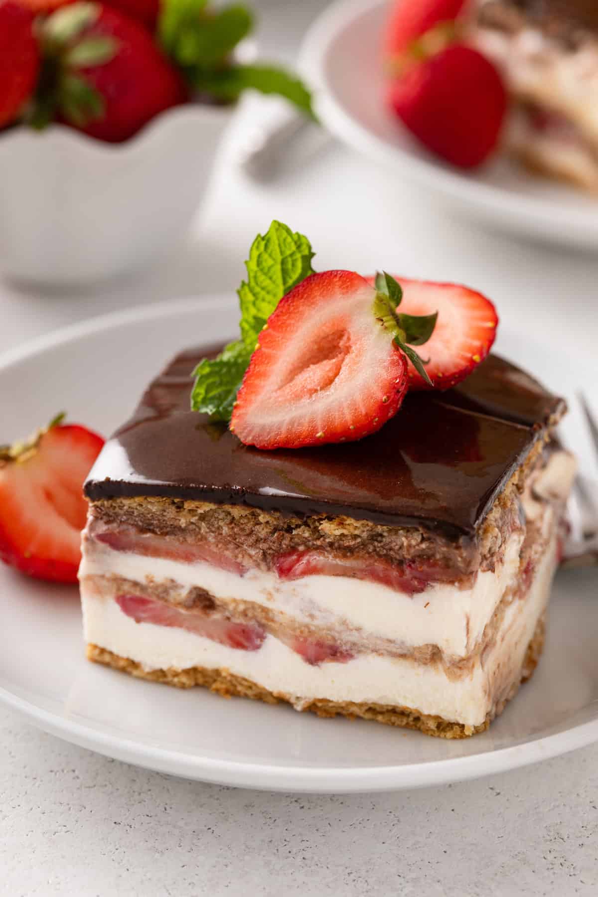 Close up view of a slice of eclair cake on a white plate.