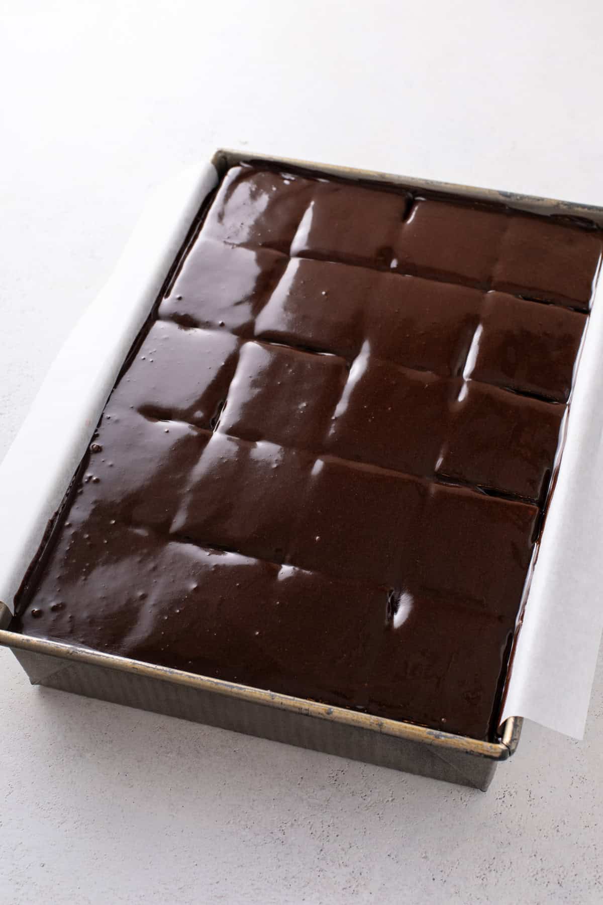 Chocolate frosting topping over an eclair cake in a baking pan.