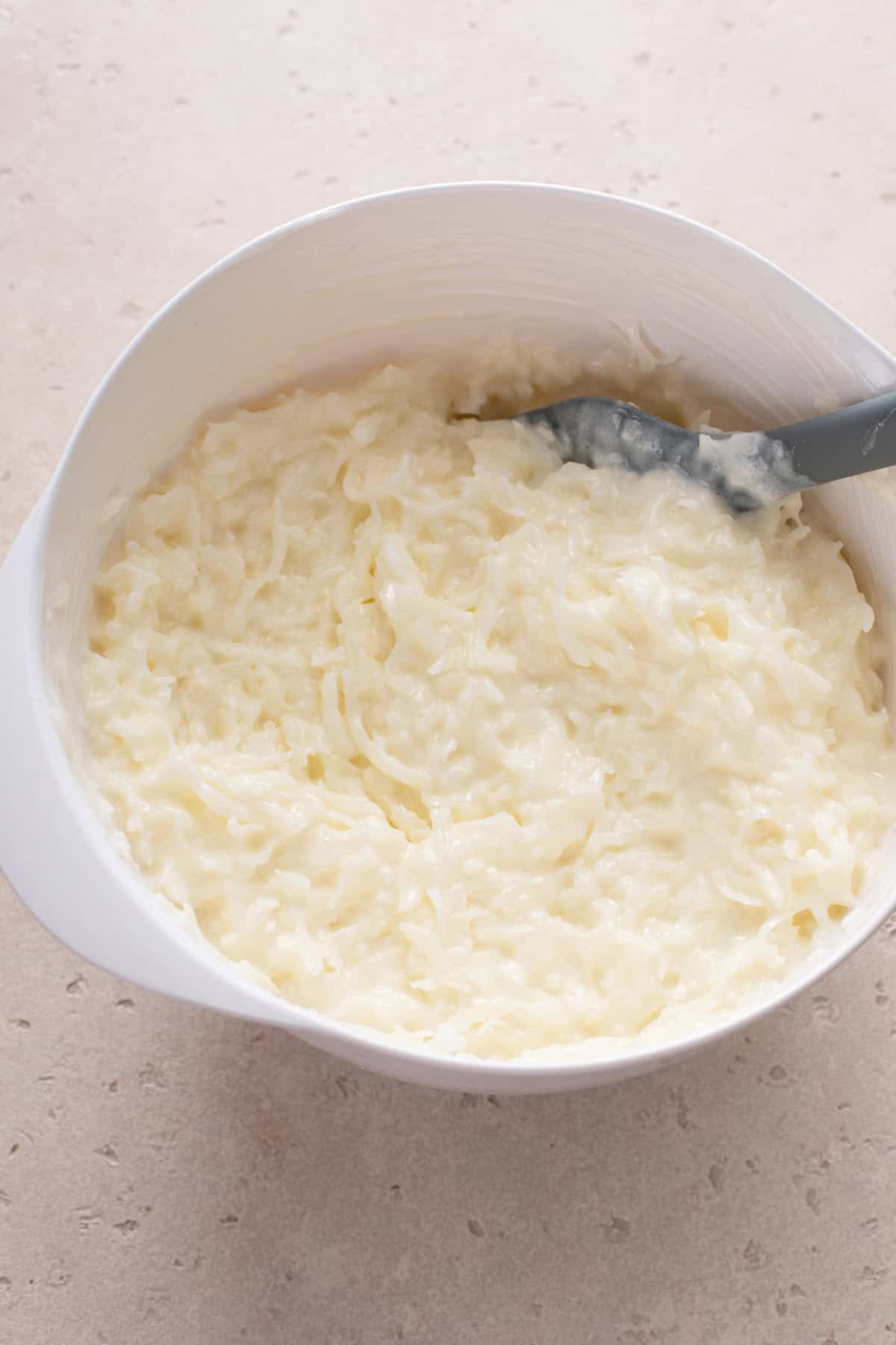 Coconut and sour cream cake filling mixed in a white bowl.