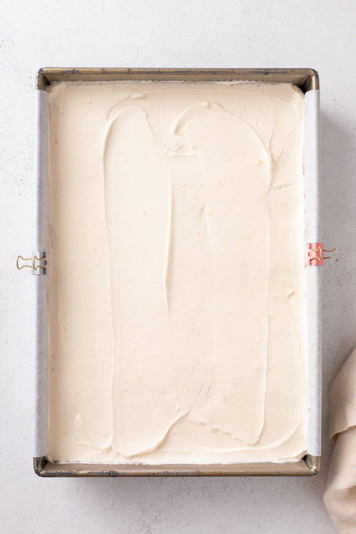 Pudding filling for eclair cake spread in a baking dish.