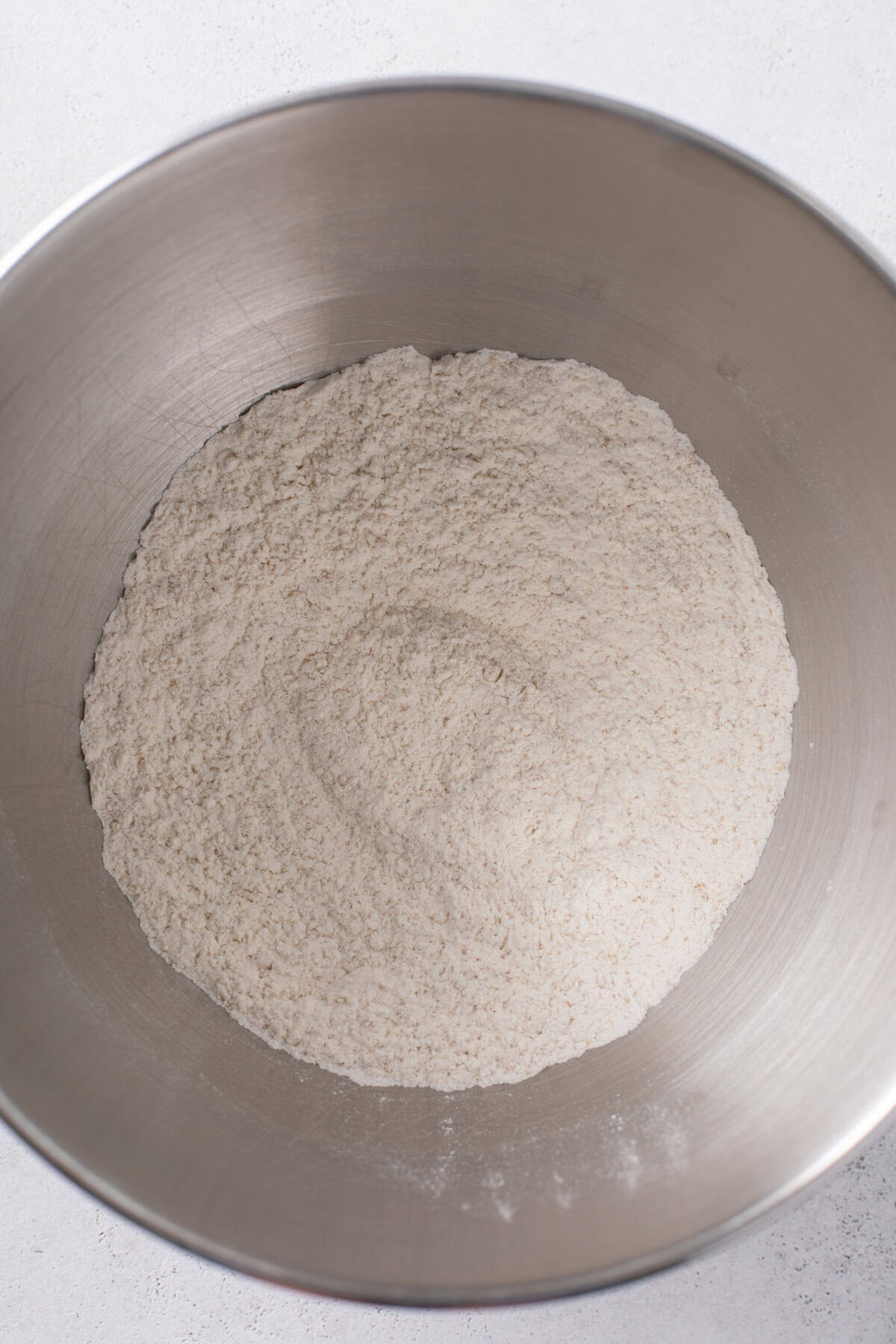 Dry ingredients for sweet rolls mixed in a stainless steel bowl.