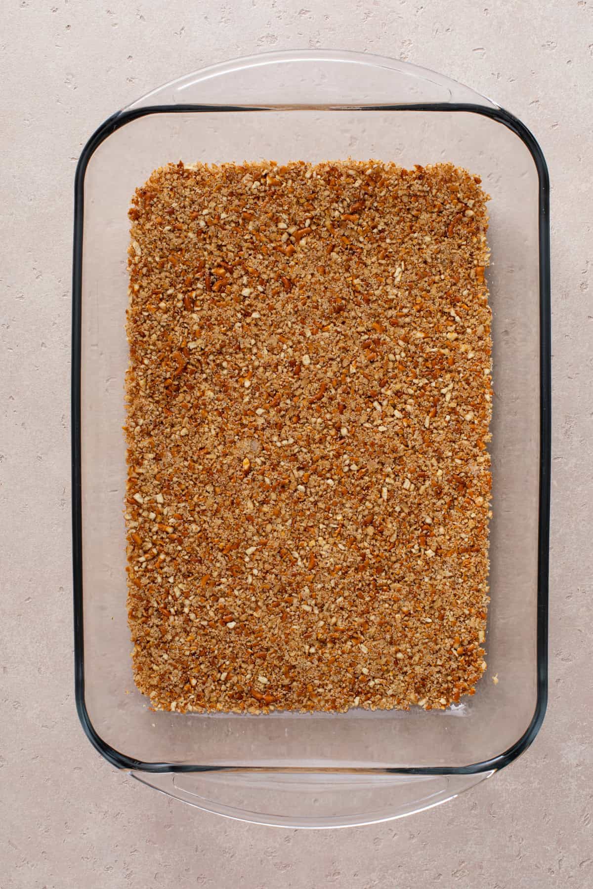 Pretzel crust pressed into a baking dish.