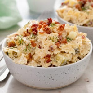 Side view of a small white bowl filled with dill pickle pasta salad.