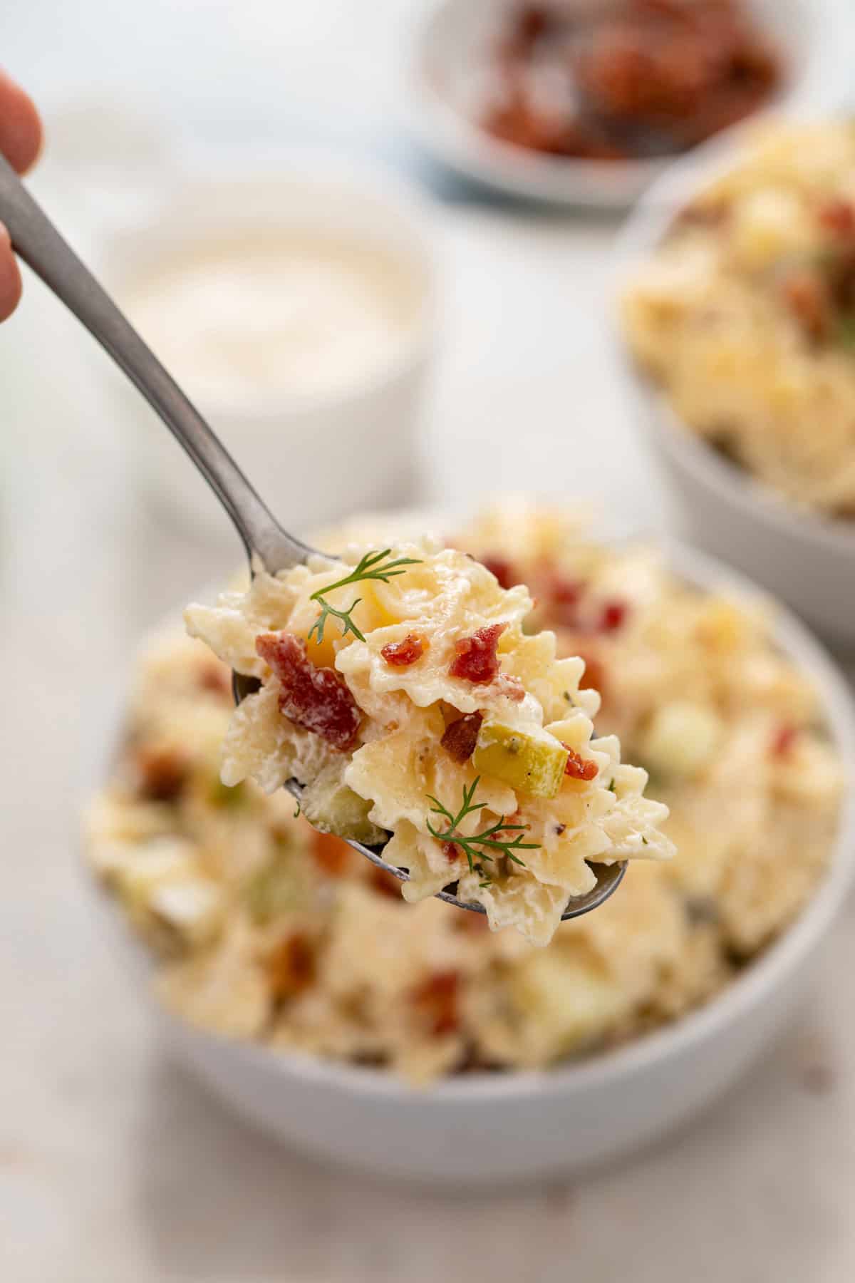 Fork holding up a bite of dill pickle pasta salad.