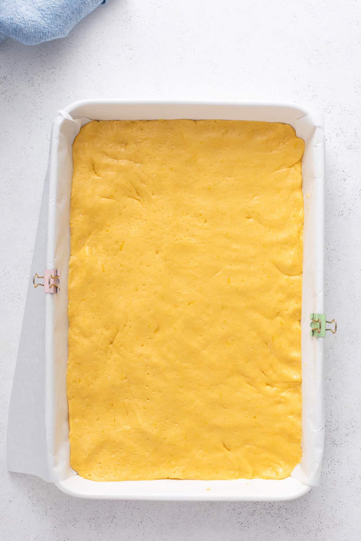 Cake batter base pressed into a baking pan for lemon gooey butter cake.