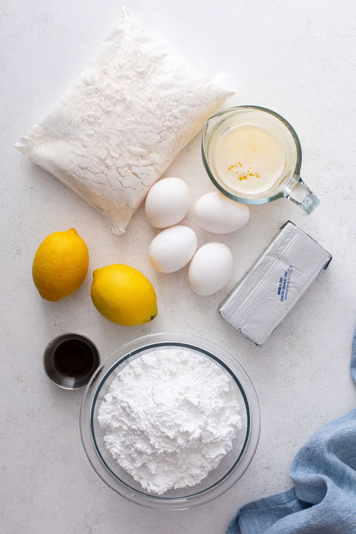 Ingredients for lemon gooey butter cake arranged on a countertop.