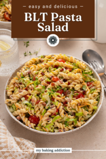 White serving bowl filled with BLT pasta salad set on a countertop next to a serving spoon. Text overlay includes recipe name.