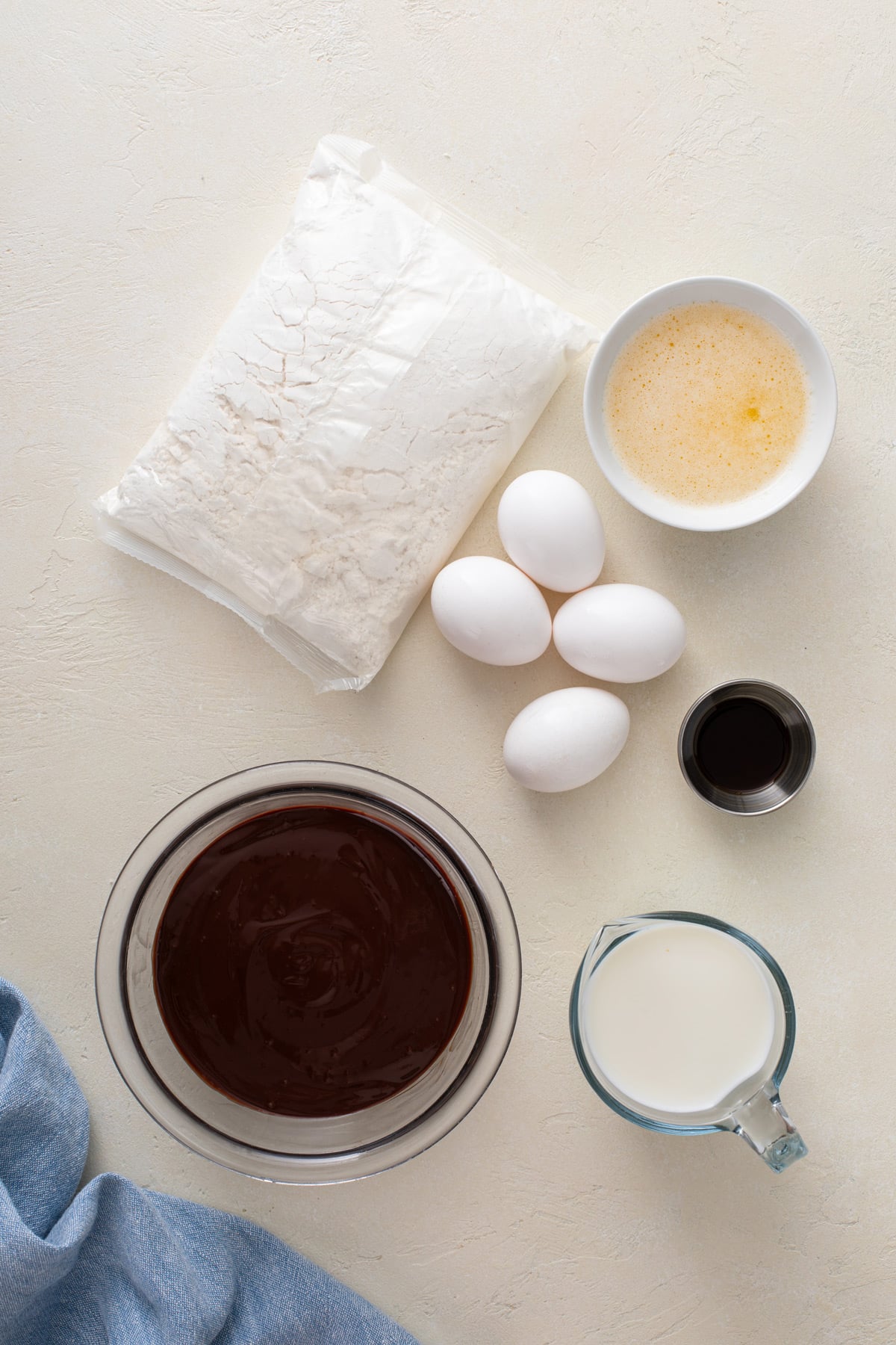 Ingredients for easy yellow sheet cake with chocolate frosting arranged on a countertop.