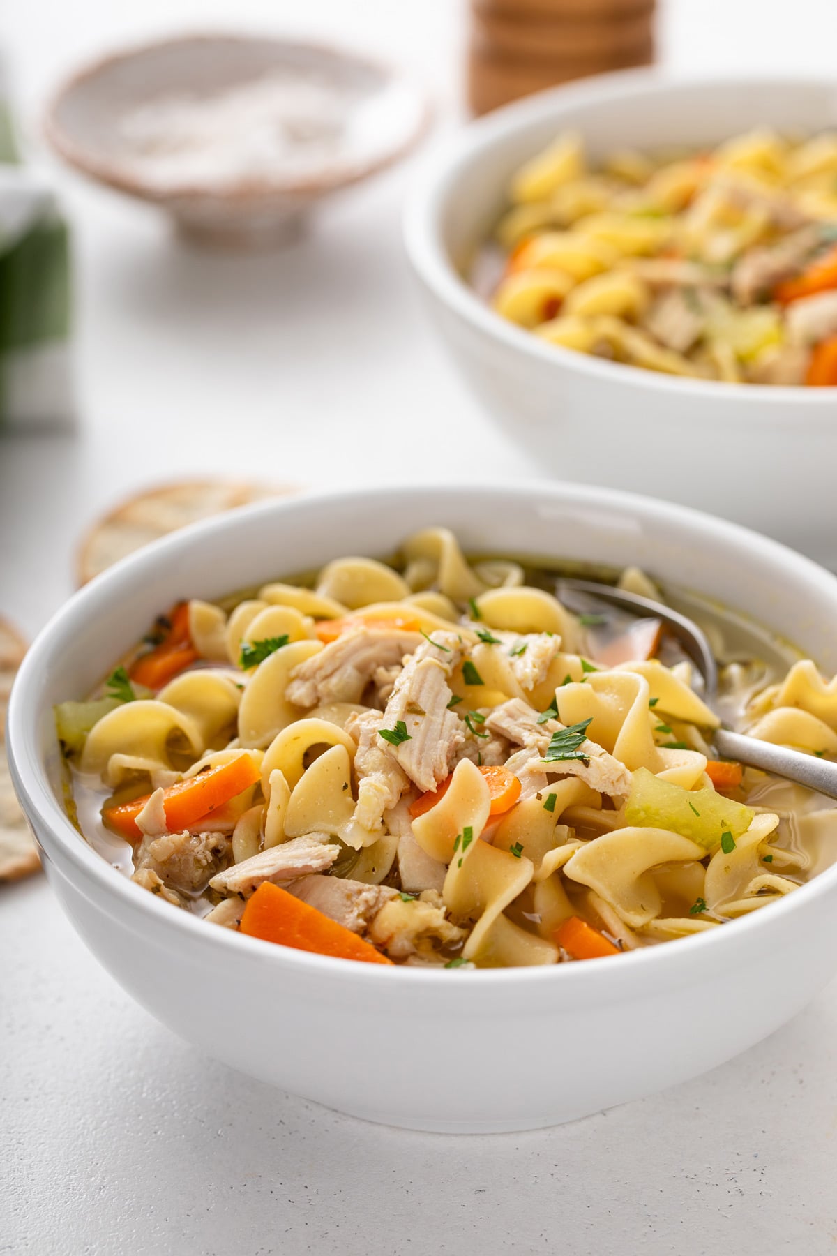 Close up of a white bowl filled with easy chicken noodle soup.