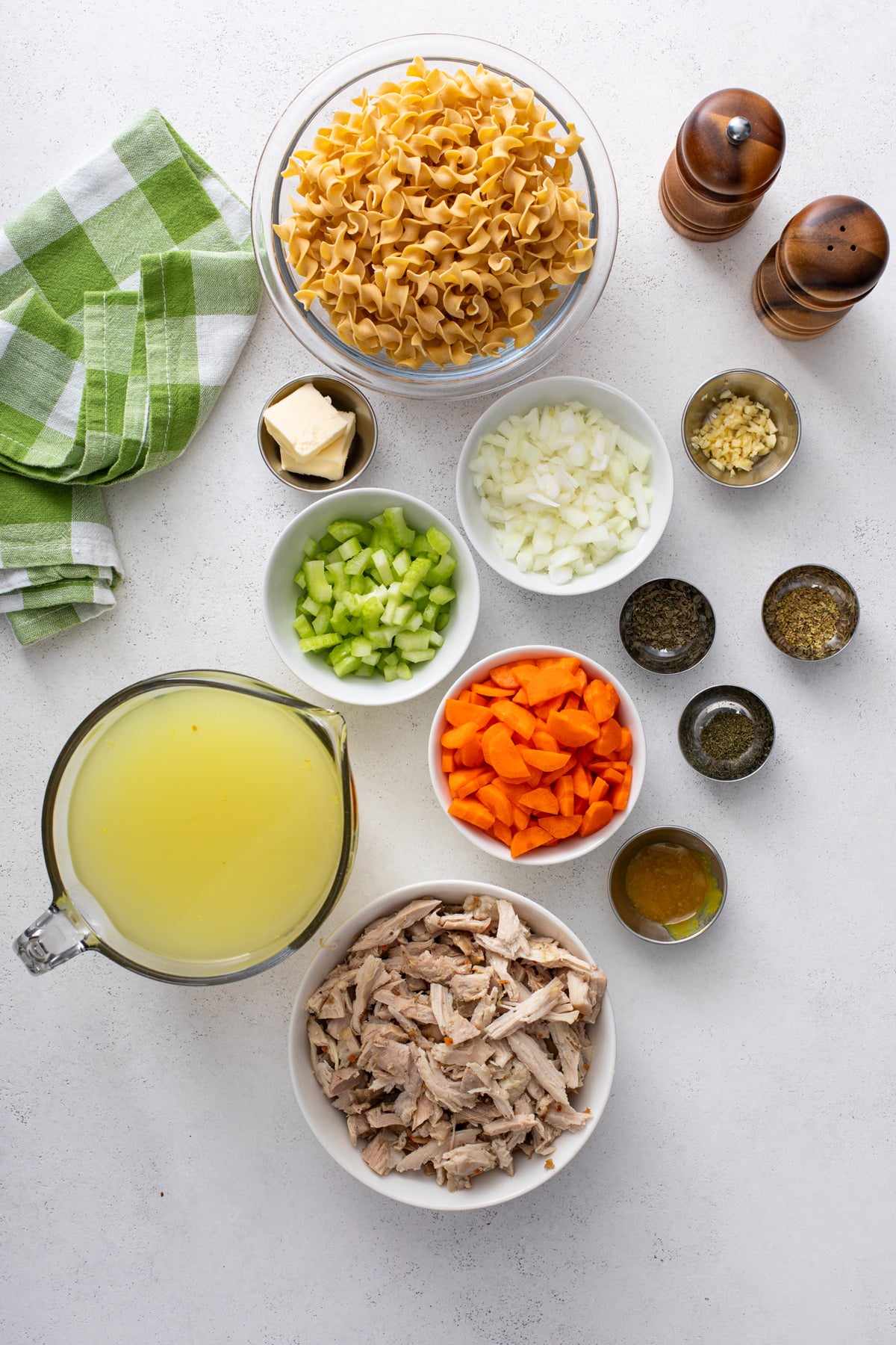 Ingredients for easy chicken noodle soup arranged on a countertop.