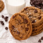 several espresso chocolate chip cookies next to a glass of milk.