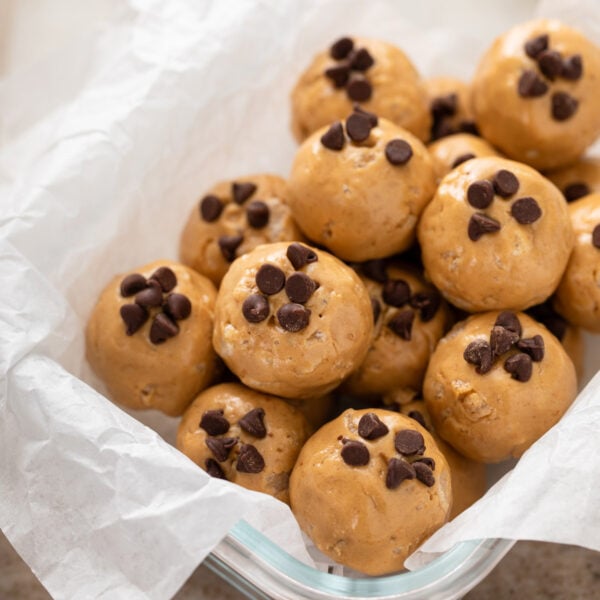 Peanut butter protein balls arranged in a storage container.