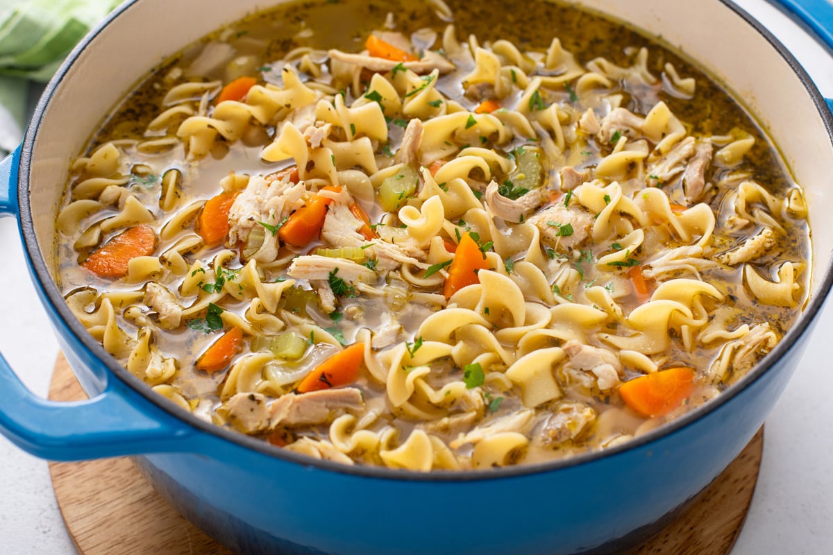 Blue dutch oven filled with easy chicken noodle soup.