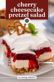 Slice of cherry pretzel salad on a white plate with a fork cutting a bite from the corner. Text overlay includes recipe name.