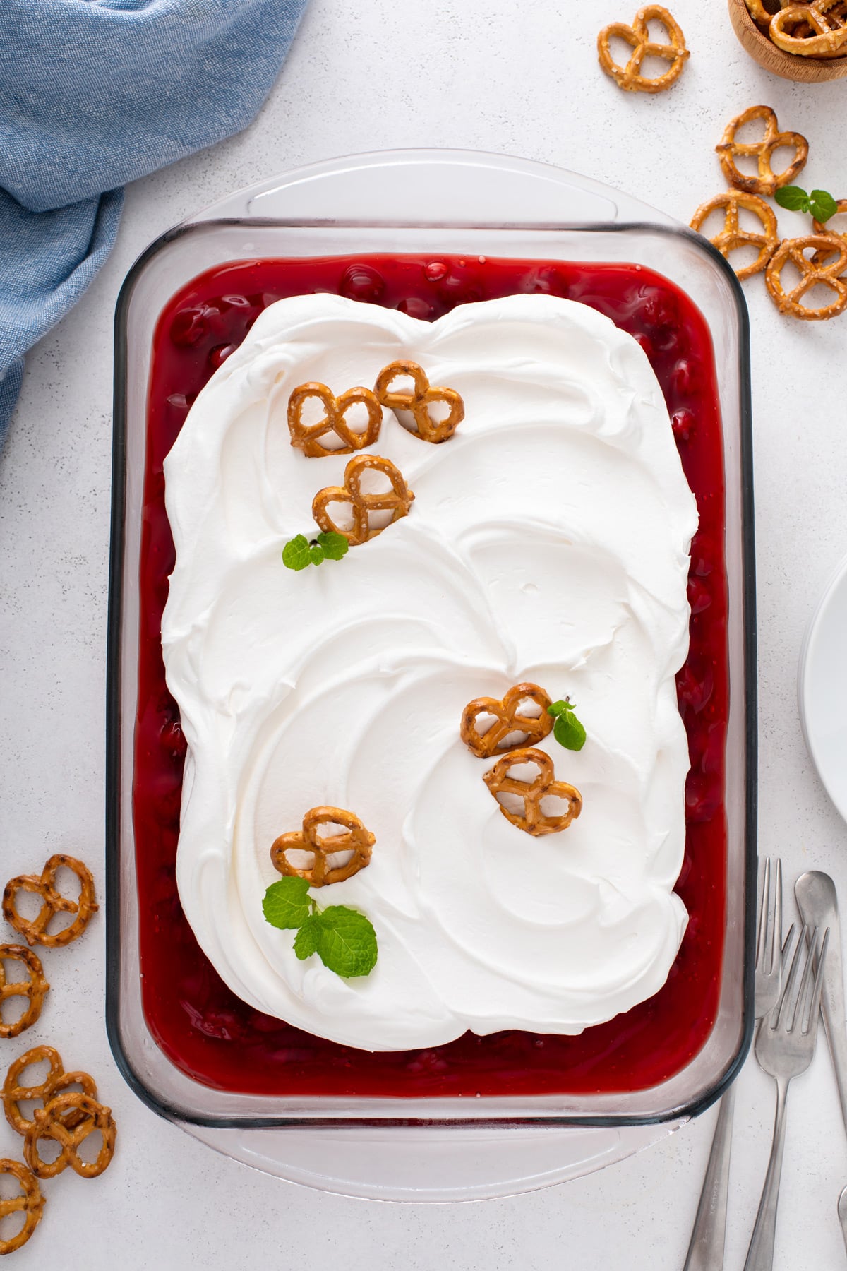 Overhead view of assembled cherry cheesecake pretzel salad garnished with pretzel twists.