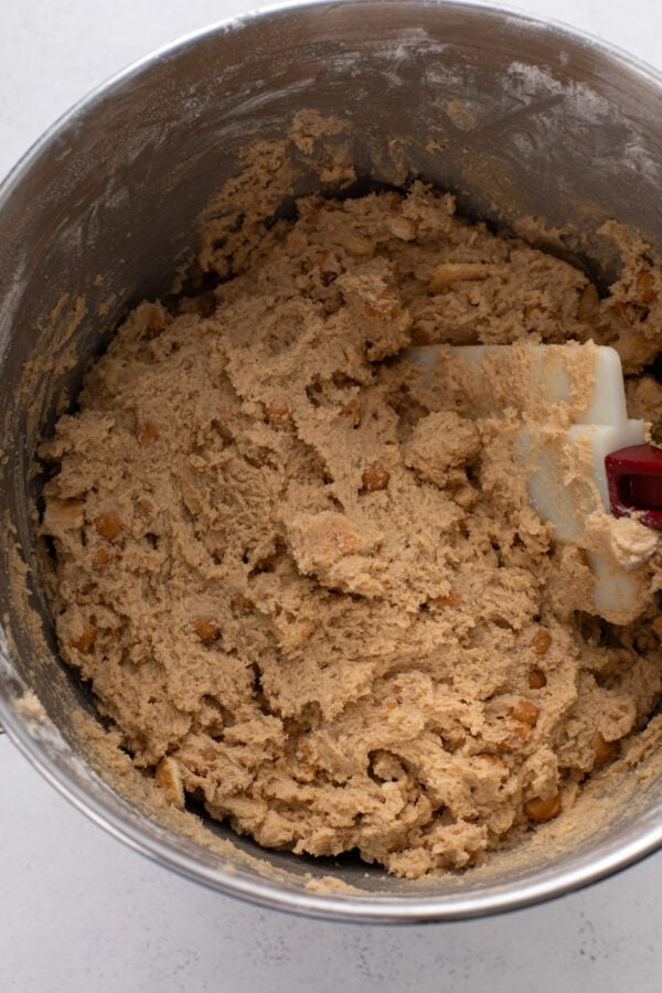 Cookie dough for caramel apple cookies in a metal mixer bowl.